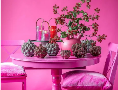 Blumige Tischdekoration in Pink mit Kerzen und Dekoelementen aus Artischocken.