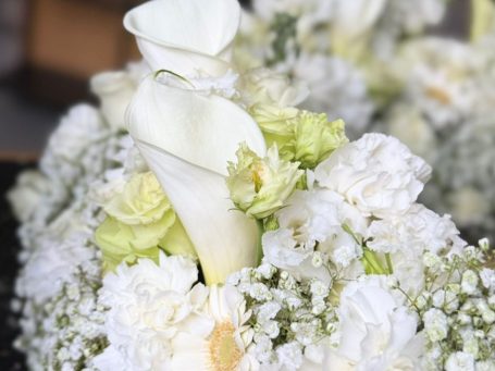 Plantula Amedorf - Trauerfloristik Ein Bouquet aus weißen Blumen mit Calla-Lilien und zarten Grüntönen.